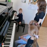 Na zdjęciu widać dziewczynki z grupy BIEDRONEK podczas gry na fortepianie.