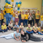 Na zdjęciu widać dzieci z grupy BIEDRONEK i bajkową postać Minionka. Jest to zdjęcie grupowe w sali.
