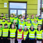 Na zdjęciu widać dzieci z grupy BIEDRONEK i JEŻYKÓW, dzieci stoją przed SP3 w Lublińcu w kamizelkach odblaskowych. Jest to zdjęcie grupowe.