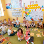 Na zdjęciu widać dzieci z grupy JEŻYKÓW, dzieci siedzą na dywanie w sali i wykonują zadanie.