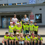 Na zdjęciu widać Panią Marysię, Panią Halinę oraz dzieci z grupy JEŻYKÓW. Jest to zdjęcie grupowe przed szkołą "Kazik" w Lublińcu.